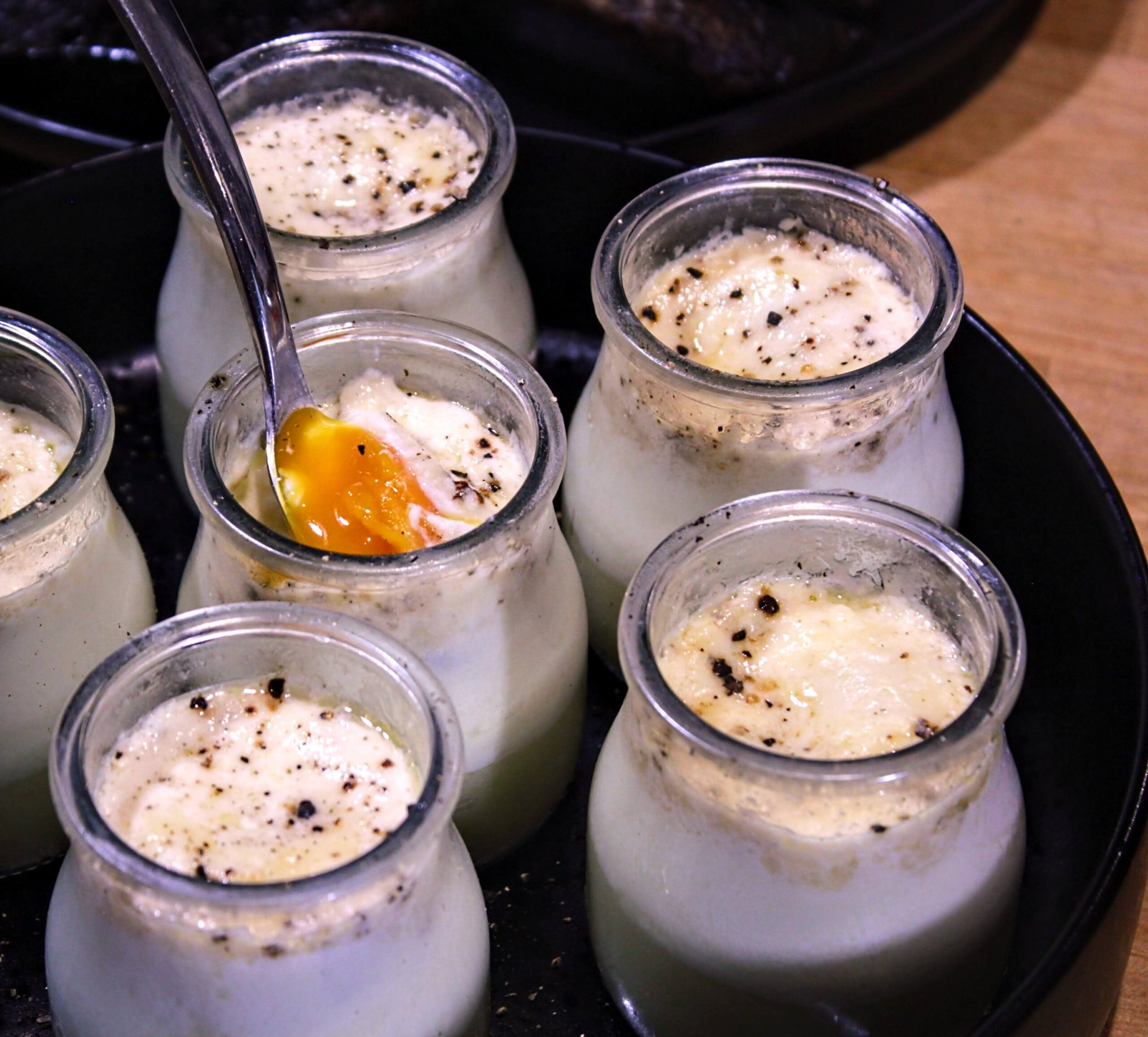 Fork inside glass jar with coddled eggs, potatoes, and leeks