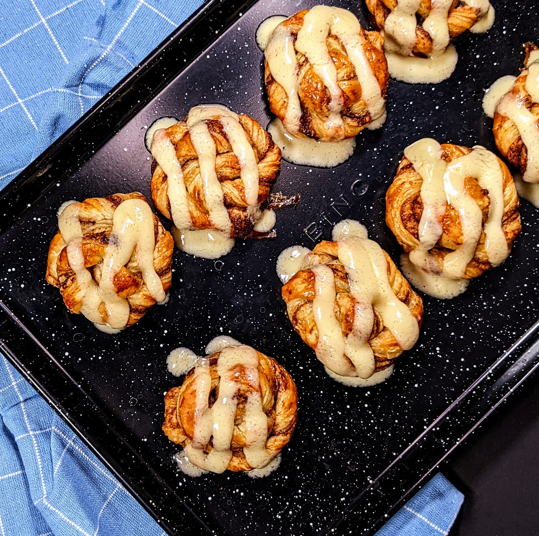 Pastries on black pan with icing